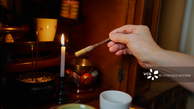 日本老年女性在家中为已故的家人和父母祈祷的特写镜头图片素材