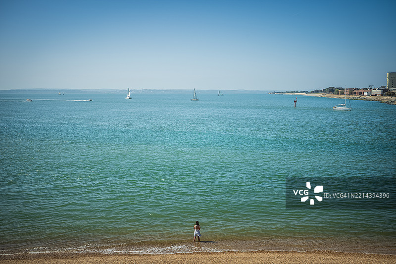 一位身份不明的女性在海滩上眺望大海图片素材