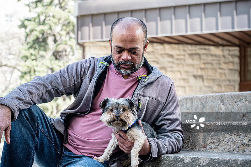 一名男子和他的狗在市中心共享宁静时刻图片素材