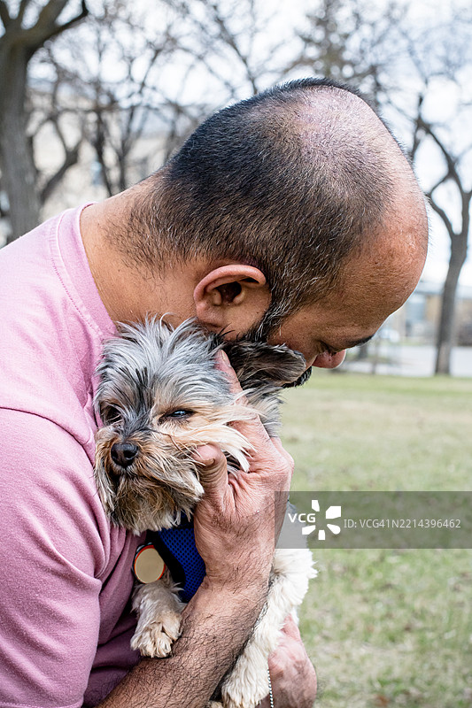 一个男人和他的狗在温馨的时刻建立亲密联系图片素材