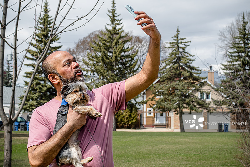 阳光明媚的春天，男人与狗自拍图片素材