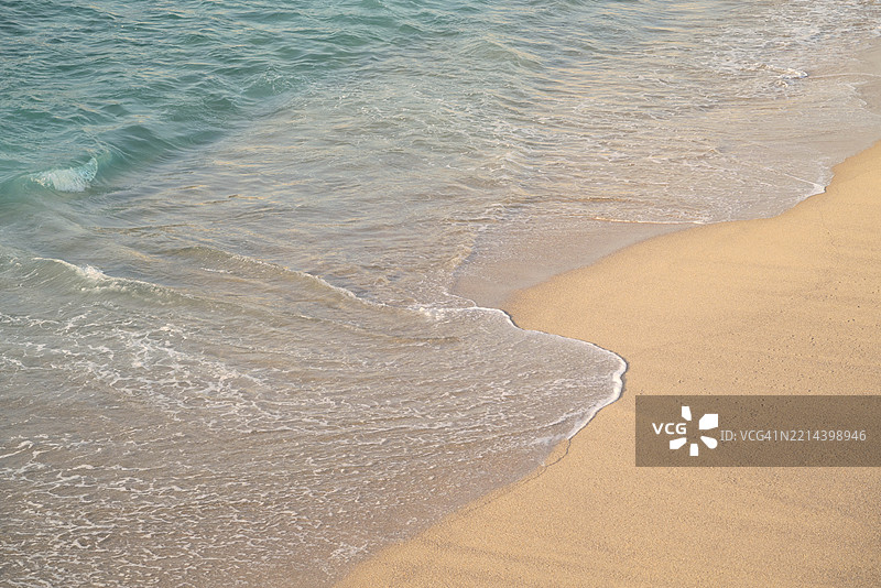 温柔的海浪在阳光明媚的日子里拍打海岸图片素材