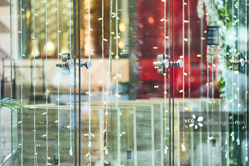 圣诞灯饰装饰着商店的玻璃门图片素材