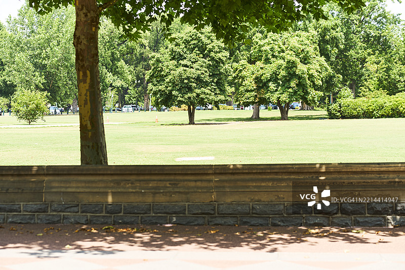 郁郁葱葱的公园，前景有树木和低矮的石墙图片素材