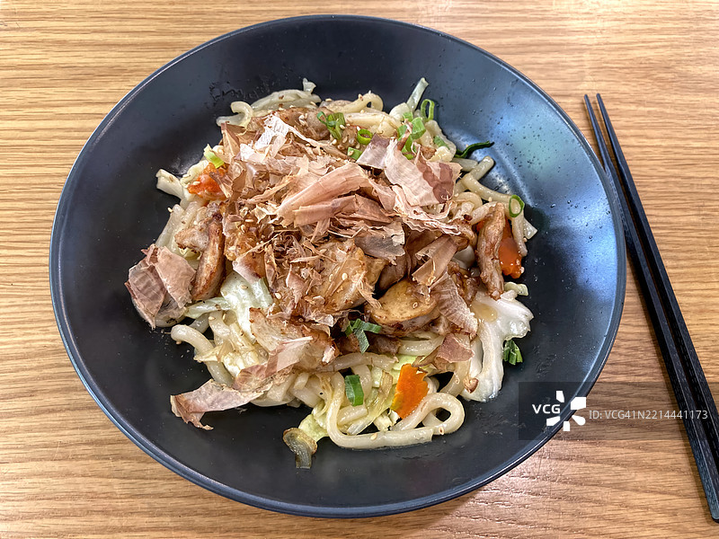 照烧鸡肉和鲣鱼片的烧烤乌冬面在碗里图片素材