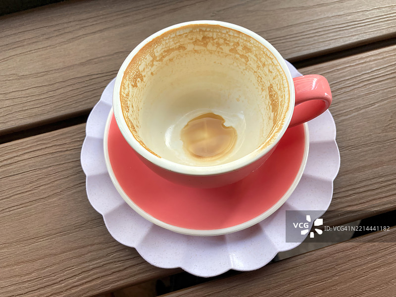 空咖啡杯和茶碟放在长椅上图片素材