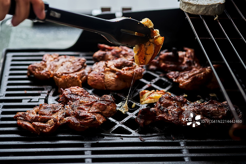 大型燃气烤架上的肉类特写。图片素材