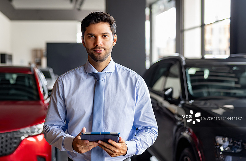 汽车经销商的销售员肖像，手持平板电脑图片素材