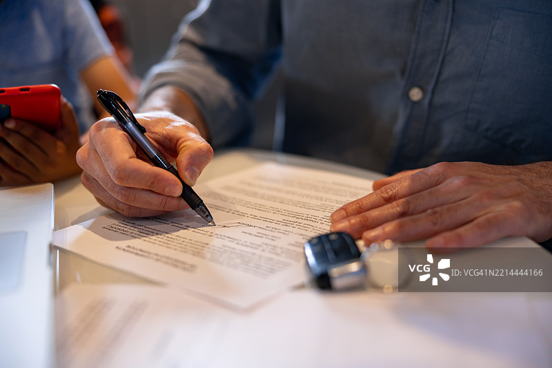 男子在汽车经销商处签署租赁合同同时购买汽车图片素材