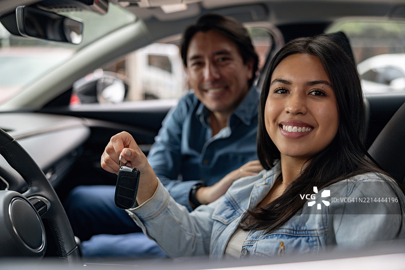 父亲和女儿在车内微笑着握着钥匙图片素材