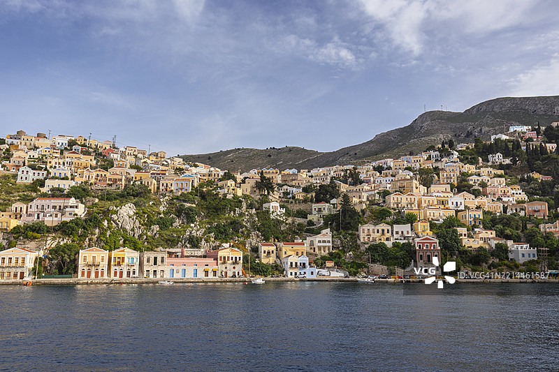 阳光明媚的日子里，希腊西米岛（Symi, Simi, Syme）上，爱琴海畔的理想小镇西米，山坡上的五彩斑斓的建筑。图片素材