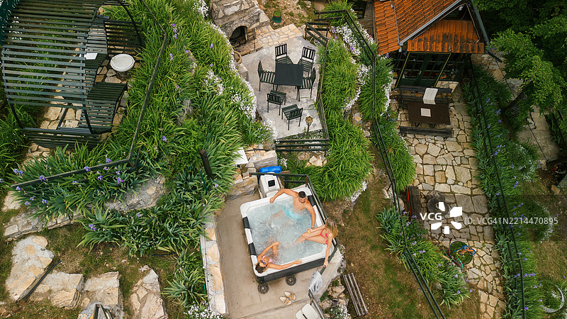 三个朋友在户外享受热水浴缸的乐趣图片素材