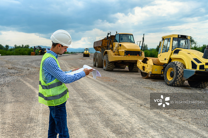 施工主管在监督道路施工时审查计划图片素材