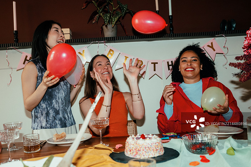 女性在生日派对上吹气球图片素材