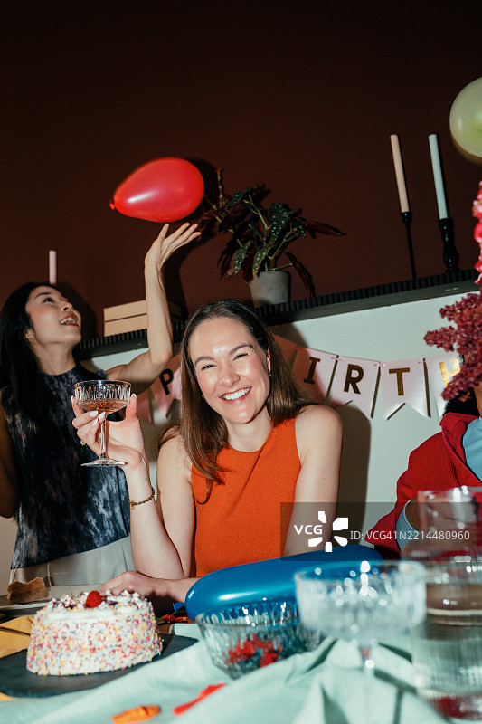 在家派对上举着香槟杯的女人图片素材