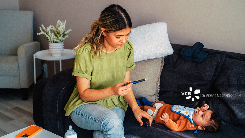 母亲在家为患有糖尿病的宝宝准备胰岛素笔。图片素材