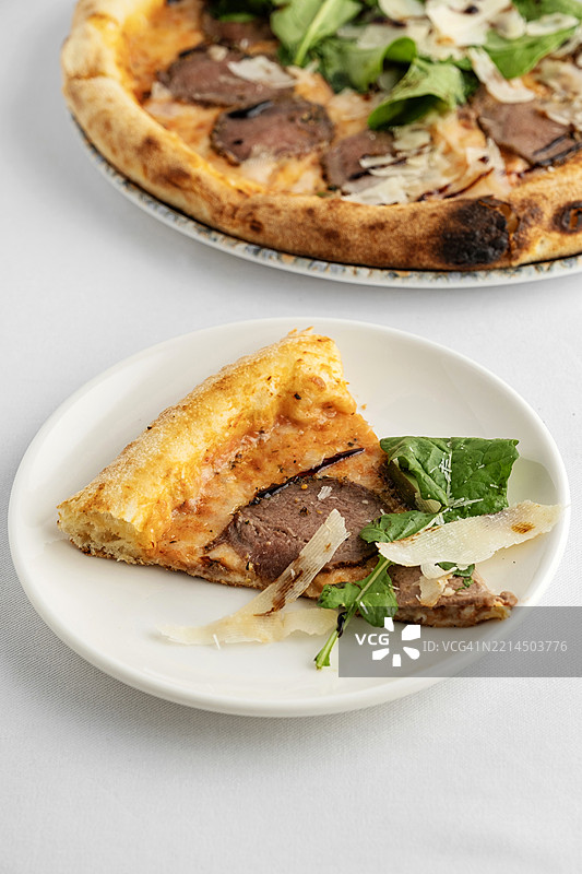 意大利那不勒斯风味肉类披萨。肉类披萨。烟熏肉和奶酪披萨。培根和火箭菜披萨。图片素材