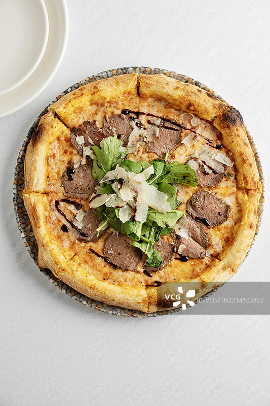 意大利那不勒斯风味肉类披萨。肉类披萨。烟熏肉和奶酪披萨。培根和火箭菜披萨。图片素材