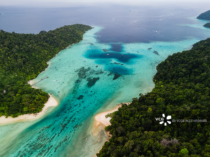 热带丛林岛屿间蜿蜒水道的航拍图，展现清澈的碧绿色海水、珊瑚礁和沙滩。图片素材