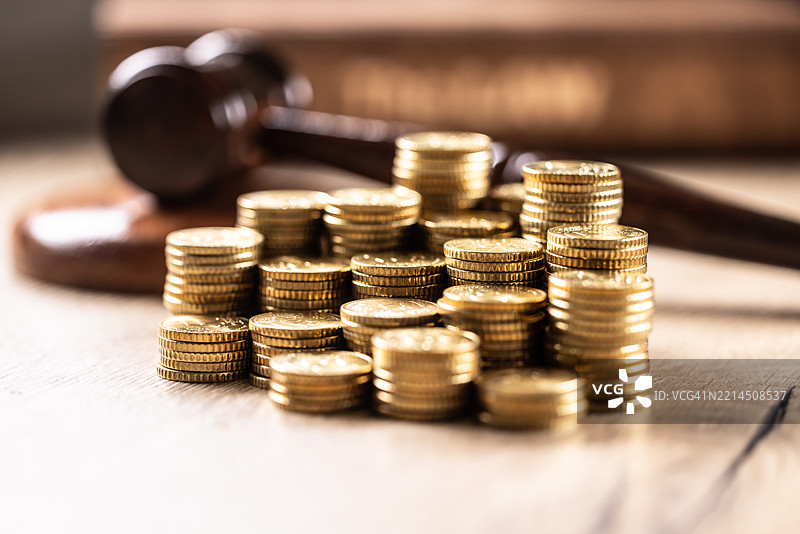 一堆欧元硬币和背景中的法官槌。司法腐败和贿赂的概念图片素材