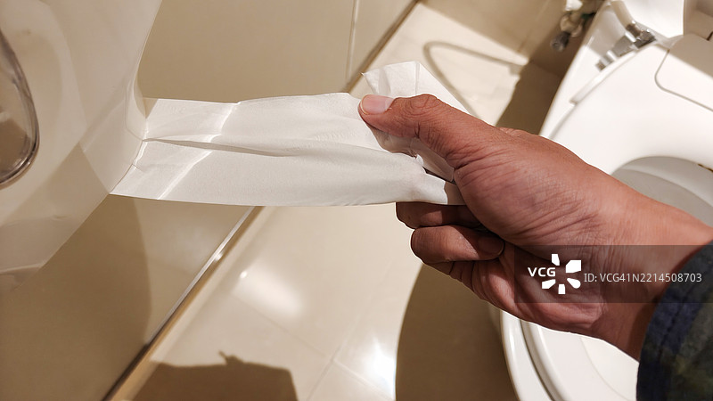 排便后拿卫生纸图片素材