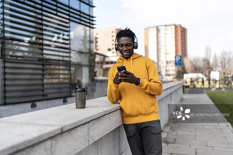 年轻运动员在训练后查看他的智能手机图片素材