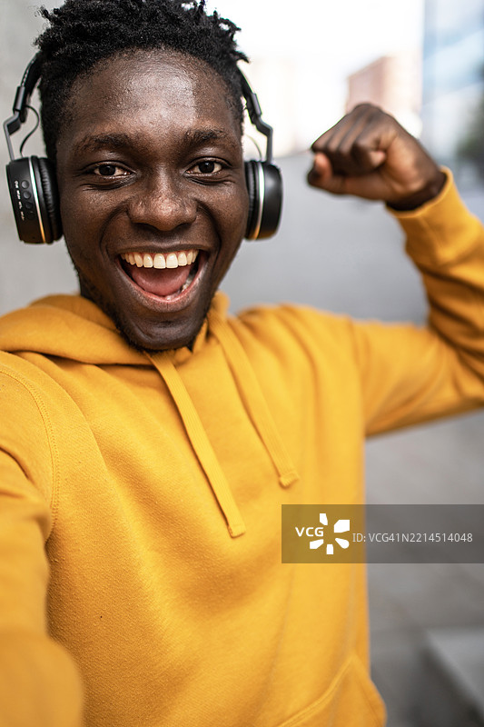 年轻男子在听音乐时感到强大，并自拍留念图片素材