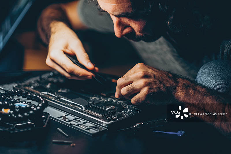 精密笔记本电脑维修和维护工作坊 - 专业技术人员在工作。图片素材