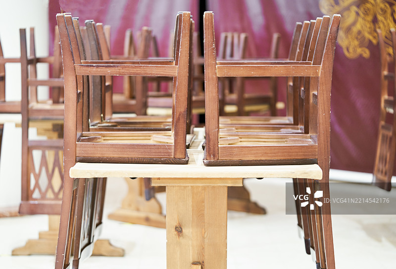 倒置的木椅叠放在桌子上，准备收起。图片素材