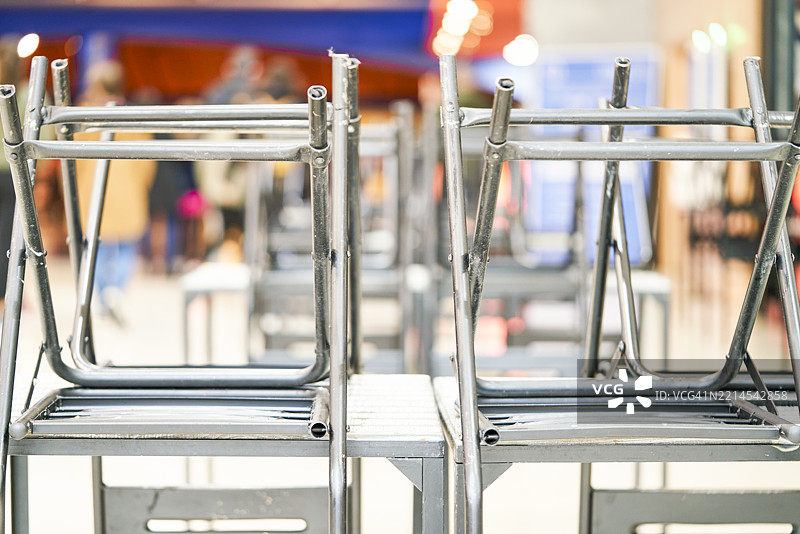 倒置在桌子上的金属椅子堆放在一个关闭的酒吧里图片素材