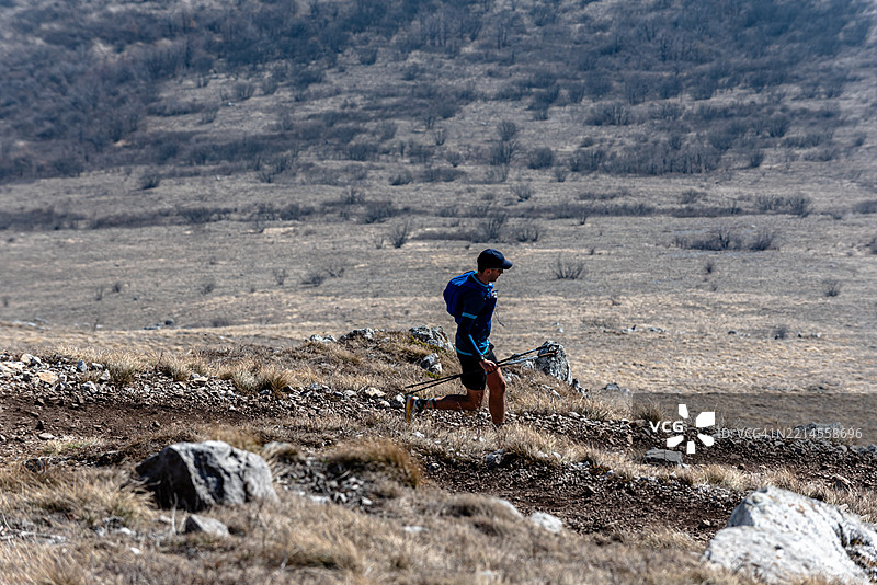越野跑运动员使用登山杖下山图片素材