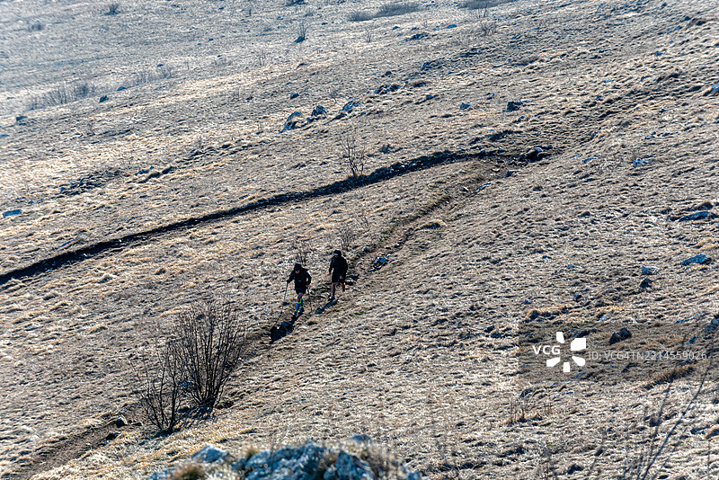 两名徒步旅行者在山间小径上行走图片素材