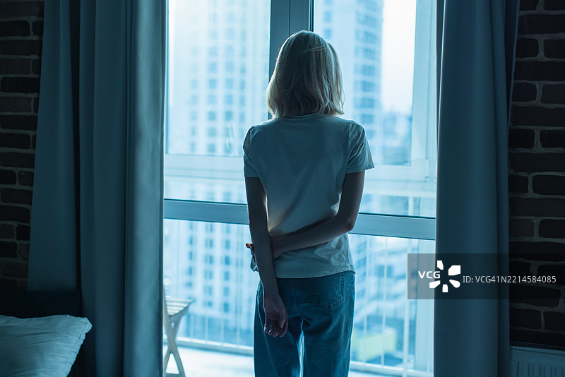 年轻女性站在窗边图片素材
