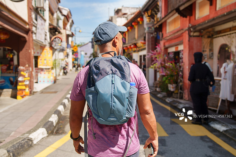 男性独自旅行者探索城市。图片素材