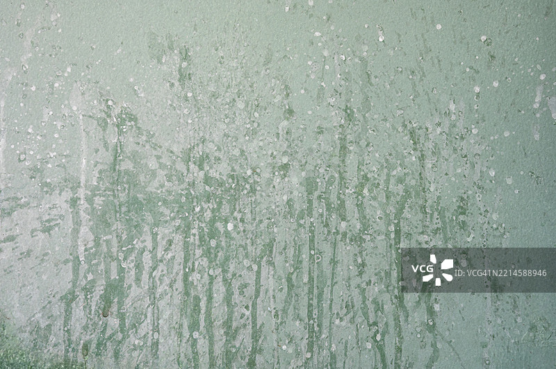 一面有白色斑点和绿色油漆的墙壁图片素材