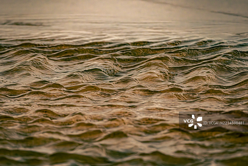 河水上日落时的金色涟漪图片素材