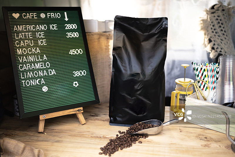 咖啡豆和勺子放在字母板旁边的价格表旁边图片素材