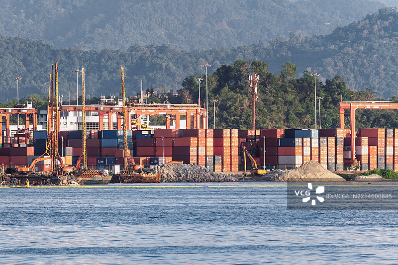 繁忙的港口，堆满了集装箱和建筑工地图片素材