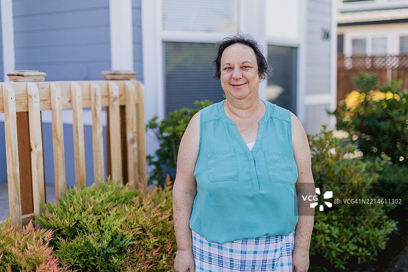 快乐的白人中年女性，五十多岁，在移动房屋社区的前院中享受时光图片素材