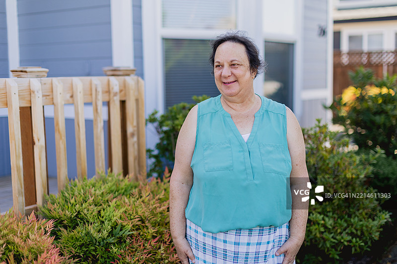 快乐的白人中年女性，五十多岁，在移动房屋社区的前院中享受时光。图片素材