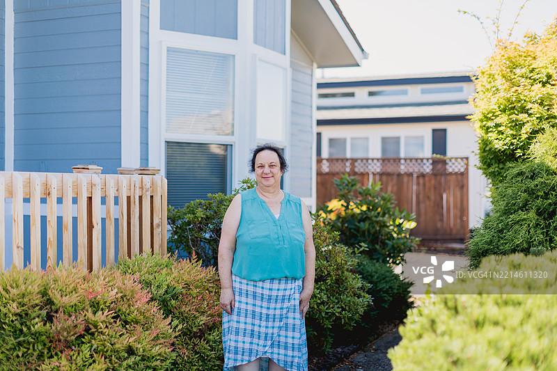 快乐的白人中年女性，五十多岁，在移动房屋社区的前院中享受时光图片素材