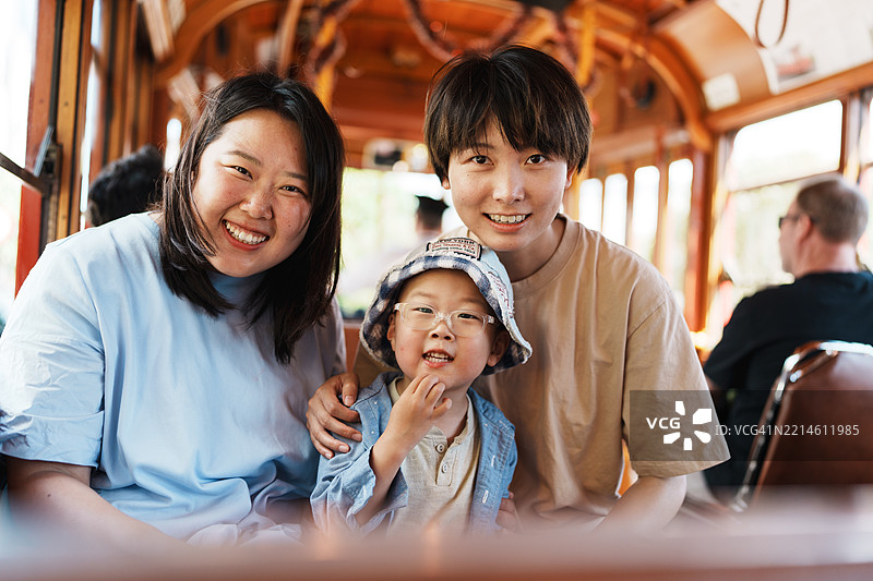 微笑的亚洲家庭一起享受有趣的电车之旅图片素材