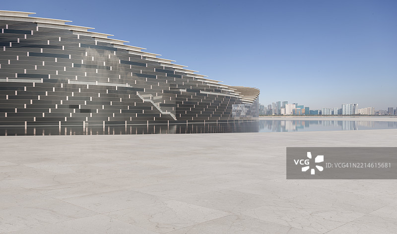 现代玻璃建筑外的 marble 地板与城市天际线图片素材
