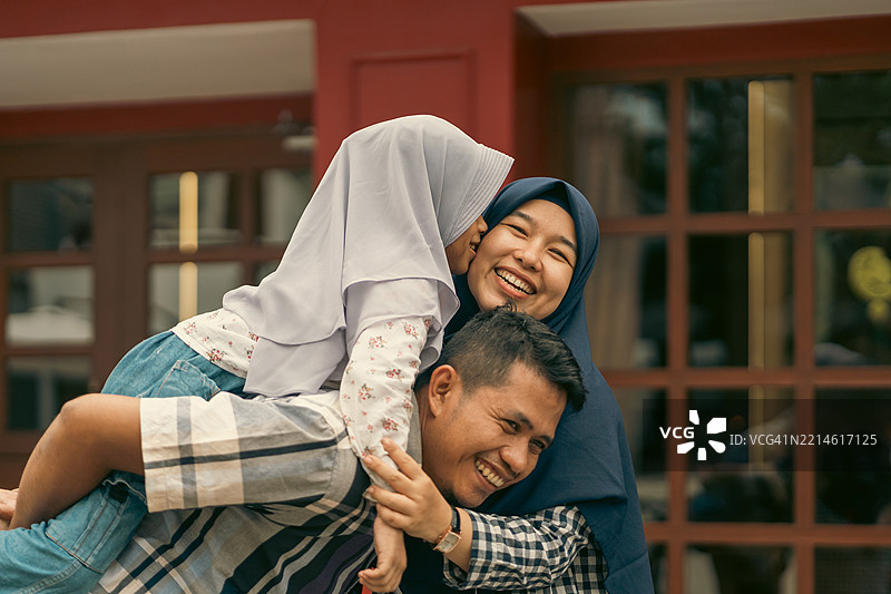 亚洲女孩亲吻母亲的脸颊肖像图片素材