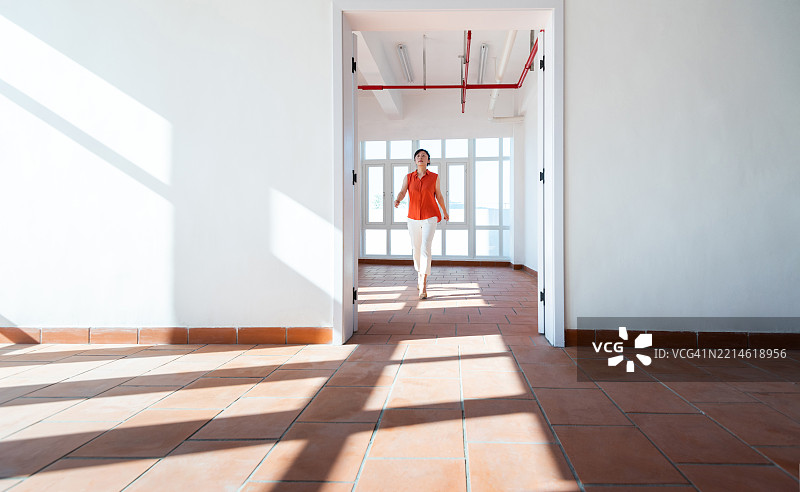 女性在现代公寓大楼内行走图片素材