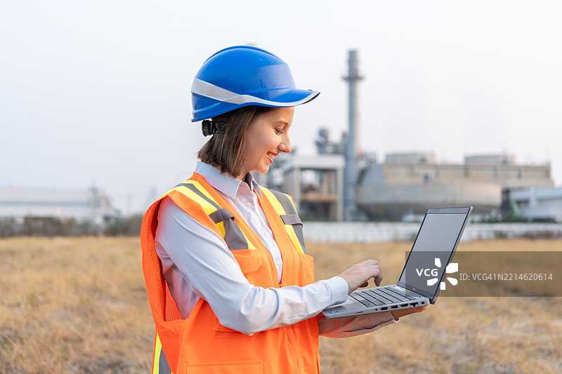 女性工程师在工业石油炼油厂进行检查，工业4.0概念，模糊背景概念。图片素材
