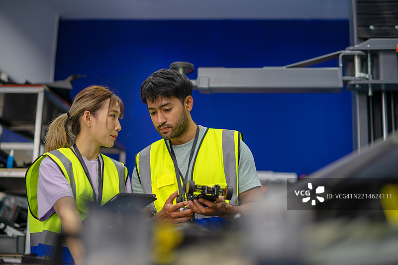 机械师在电动车维修车间工作。图片素材