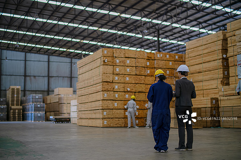 蓝领工人在木材厂工作。图片素材