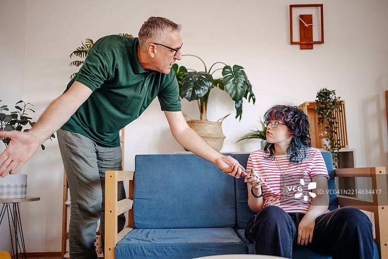 父亲在家与他的青少年女儿进行严肃的谈话图片素材