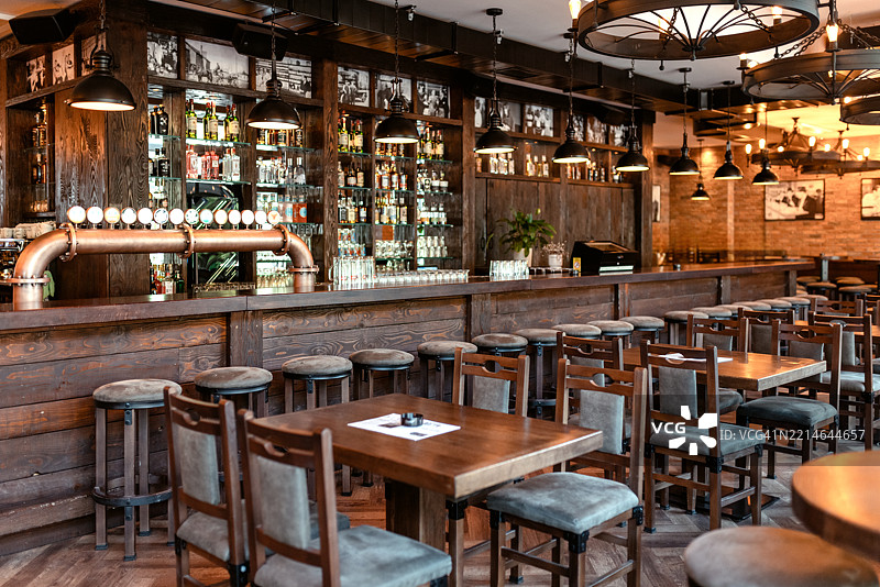 复古酒吧内部，配有木质家具和氛围灯光图片素材